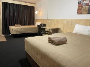 A bed or beds in a room at Countryman Motor Inn Cowra