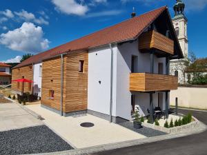 uma pequena igreja branca e de madeira com uma torre em wohnung-nummer-3 em Pielenhofen