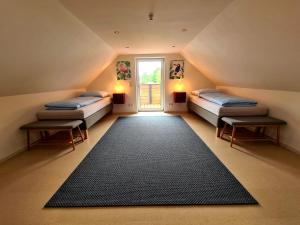 a attic room with two beds and a large rug at wohnung-nummer-3 in Pielenhofen
