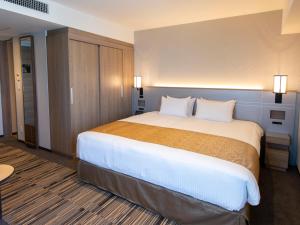
a hotel room with a bed and a dresser at Asakusa Tobu Hotel in Tokyo
