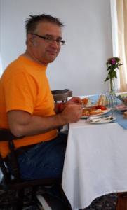un hombre sentado en una mesa con un plato de comida en The Countryman Hotel en Camelford