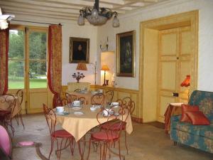 uma sala de jantar com uma mesa e cadeiras e um sofá em Chateau de la Rue em Cour-sur-Loire