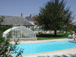 ein Pool mit einem Gewächshaus neben einem Haus in der Unterkunft Chateau de la Rue in Cour-sur-Loire