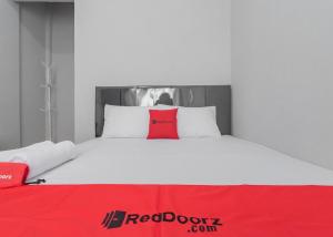 a bed with a red door sign on top of it at RedDoorz Syariah near Wisata Situ Gunung Sukabumi in Kadudampit