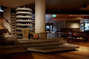 Una habitación con una mesa con jarrones. en Ovolo Nishi en Canberra