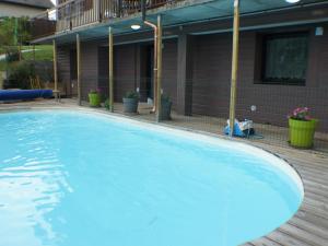 une grande piscine bleue en face d'un bâtiment dans l'établissement gîtes des planchettes, à Marigny