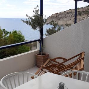a balcony with a table and chairs and the ocean at Big Blue Studios Myrtos in Myrtos
