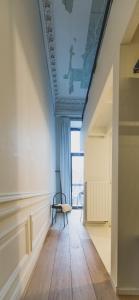 een kamer met een plafond met een stoel en een raam bij The Hide in Gent