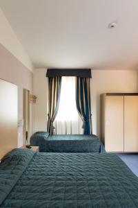 a bedroom with two beds and a window at Hotel Fiera Rho in Rho