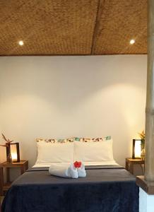 a bedroom with a bed with two towels on it at Valerie Lodge in San Vicente