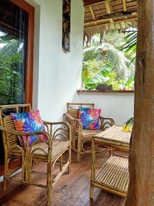 - un ensemble de chaises assises sur une terrasse couverte dans l'établissement Valerie Lodge, à San Vicente