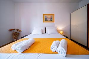 a bedroom with a large bed with towels on it at Apartments Lazarić in Lopar