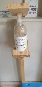 a bottle on a wooden shelf under a sink at Twilight Cottage in Plettenberg Bay