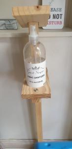 a bottle on a wooden shelf under a sink at Twilight Cottage in Plettenberg Bay