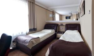 ソスノヴィエツにあるM Hotel Sosnowiecのベッド2台と窓のある病室です。