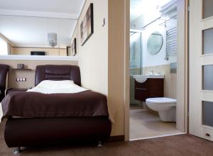 1 dormitorio con cama, lavabo y aseo en M Hotel Sosnowiec, en Sosnowiec