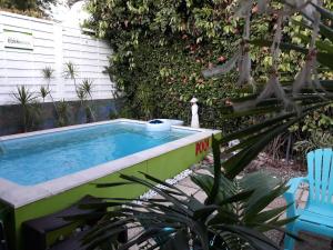 una piscina en un patio con una silla azul en Villa Eden Rock, en Schœlcher