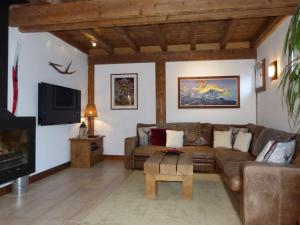 a living room with a couch and a tv at Chalet Le Pery in Châtillon-sur-Cluses