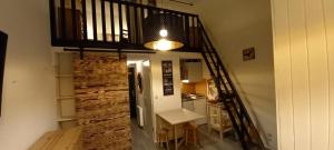 a room with a staircase with a table and a kitchen at Duplex Arc en Ciel - Les Deux Alpes in Mont-de-Lans