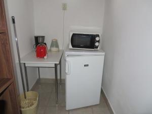 a microwave sitting on top of a refrigerator at Csányi vendégház in Kiskunmajsa