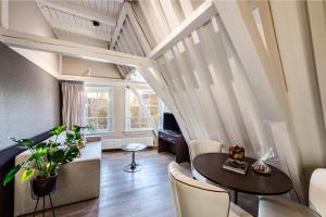 a living room with a table and chairs at NH Collection Barbizon Palace Apartments in Amsterdam