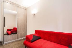 - un canapé rouge dans une pièce avec un miroir dans l'établissement Luxury 3BR Apt Centrally Located & 5-min to Beach by Sea N' Rent, à Tel Aviv