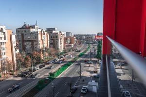 - une vue sur une rue de la ville avec des voitures et des bâtiments dans l'établissement Puzzle Apartaments&Studios, à Craiova