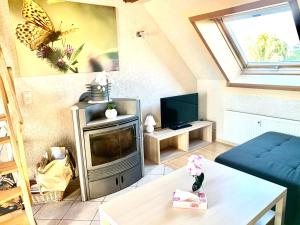 - un salon avec une télévision et un papillon sur le mur dans l'établissement #WORLD Ferienwohnung Schkeuditz, à Schkeuditz
