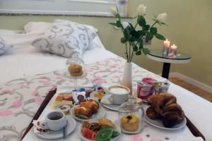 a breakfast tray with pastries and coffee on a bed at Villa Isa in Pescara