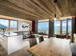 a kitchen and living room with a table and chairs at Sporerhof Dolomitenlogen in Obergaimberg