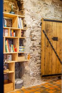 uma porta de madeira numa parede de pedra com estantes de livros em Le Cours Saint Pierre - Entre Château et Cathédrale em Nantes