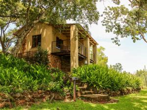 an old stone house with a balcony in the yard at Bohm's Zeederberg Country House in Hazyview