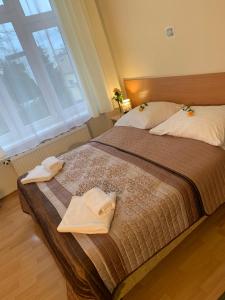 sypialnia z 2 ręcznikami na łóżku z oknem w obiekcie OW Meduza i Biala Mewa w mieście Międzyzdroje