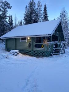 una casa con un tetto innevato nella neve di Riverside Cottage near Ylläs, Lapland a Kittilä