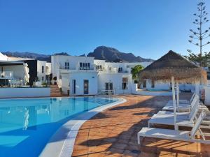 a swimming pool with white buildings and a resort at Flamingo Beach Mate in Adeje