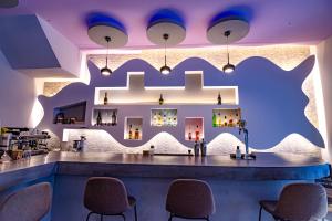 un bar en un restaurante con iluminación púrpura en N E P center Hotel Rodos en Rodas