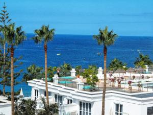 a view of a building with palm trees and the ocean at Flamingo Beach Mate in Adeje
