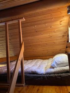 Posto letto in camera con parete in legno. di Riverside Cottage near Ylläs, Lapland a Kittilä