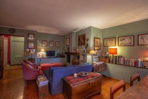 a living room with a blue couch and a table at L'Atelier du Temps - PincherleStyle Apartment in Courmayeur