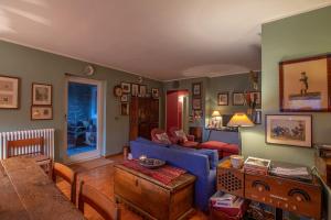 a living room with a blue couch and a table at L'Atelier du Temps - PincherleStyle Apartment in Courmayeur