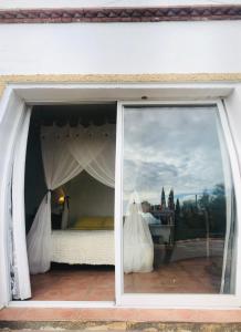 een slaapkamer met een bed in een raam bij Cortijo el Abejaruco in Almuñécar +27 foto's