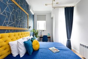 クラクフにあるLuxe Living Krakowのベッドルーム(青いベッド1台、黄色いヘッドボード付)