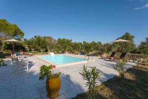 a swimming pool with chairs and a table at Liuba Houses in Vasilikos