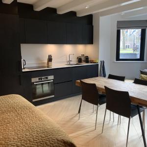 cocina y comedor con mesa y sillas en B&B Florapark, en Haarlem