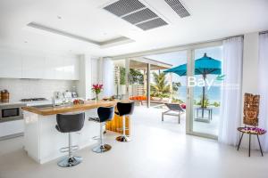 eine Küche mit einer Theke mit Stühlen und einer Insel in der Unterkunft Bay Villas Koh Phangan in Salad Beach