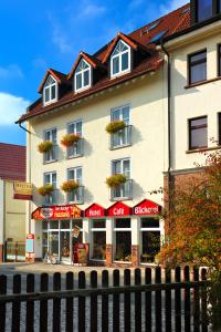 een groot wit gebouw met bloemen op de ramen bij Hotel Fabrice in Bad Klosterlausnitz