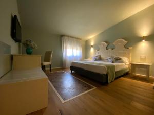 a bedroom with a bed and a table and a television at Hotel Foresteria Baglio Della Luna in San Leone