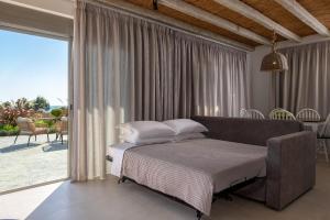 a bedroom with a bed and a large window at Anemos Villas in Lachania +39 photos