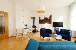 a living room with a blue couch and a table at Wohnung mit Blick auf die Zitadelle Petersberg - 3 Zimmer in Erfurt