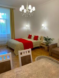 ein Schlafzimmer mit einem großen Bett mit roten Kissen in der Unterkunft Siesta apartment on Stefanyka in Lwiw